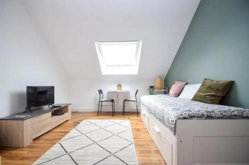 une chambre avec un lit, une télévision et une table dans l'établissement 10mn RER B Aéroport CDG - Paris Gare du Nord, T11 Express, Le Bourget, All equipped, Free Netflix, From 1 to 3 Guests, 4th Floor by Stairs, Escaliers, Parc des Expositions, Free Street Parking after 7pm - 2, à Drancy