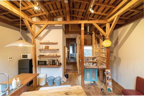 a large room with wooden ceilings and a kitchen at HamaVilla in Tottori