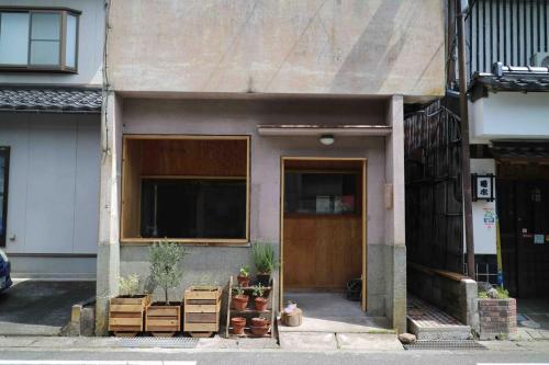 a building with a door and some potted plants at HamaVilla in Tottori