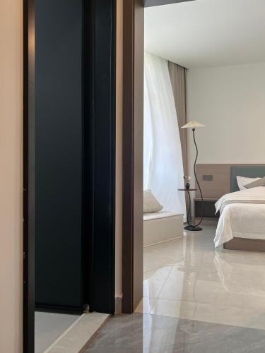a bedroom with a bed and a room with a window at Wangxian Mountain Retreat B&B-Wangxian Valley Scenic Area in Qiaotou