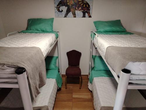 two bunk beds in a room with a chair at La Mini Polo in General Rodríguez