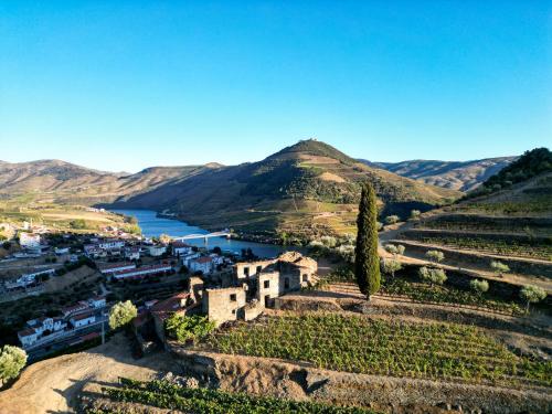 a village on a hill with a river and mountains at Dois Lagares House in Pinhão