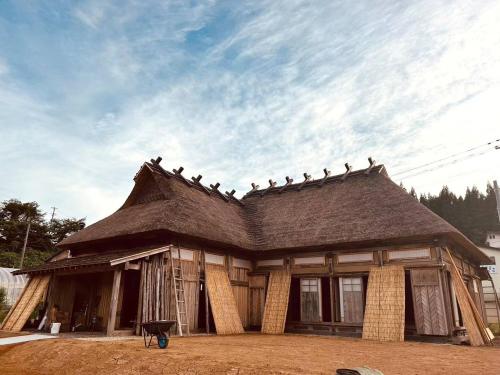 a building with birds sitting on top of it at うご八かやぶ㐂 in Narazaki