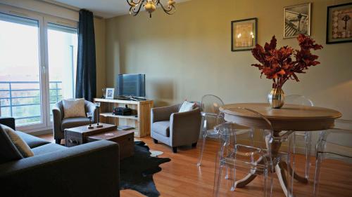 un salon avec une table, des chaises et une télévision dans l'établissement Little Suite - Westhoek, à Lille