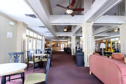 a dining room with tables and chairs and a ceiling at Whimsical Condo 1.5M from Disney in Orlando
