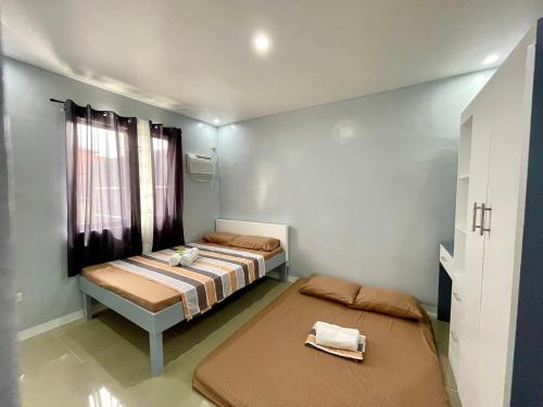 a bedroom with two beds and a window at MC2 Homestay Butuan in Butuan