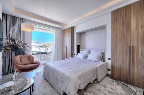 une chambre avec un grand lit et une grande fenêtre dans l'établissement Luxury Superbe Studio Miramar Croisette, à Cannes