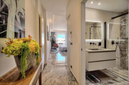 La salle de bains est pourvue d'un lavabo et d'un vase de fleurs jaunes. dans l'établissement Luxury Superbe Studio Miramar Croisette, à Cannes