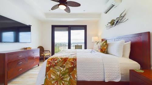 a bedroom with a bed and a ceiling fan at 360 Splendor 208A- Ocean View Condo, Breakfast in Playa Flamingo