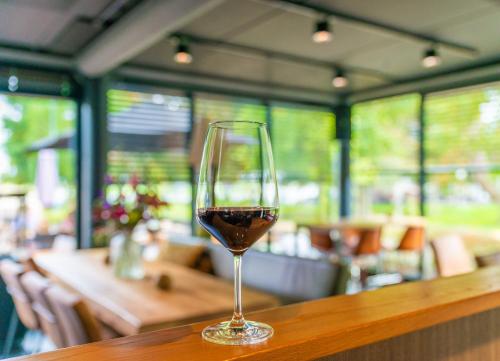 a glass of wine sitting on a wooden table at Boutique Hotel Karel de Stoute in Gorinchem