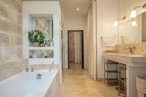 une salle de bain avec une grande baignoire et deux lavabos dans l'établissement Dormir dans une église du 13ème siècle au coeur d'Avignon, à Avignon