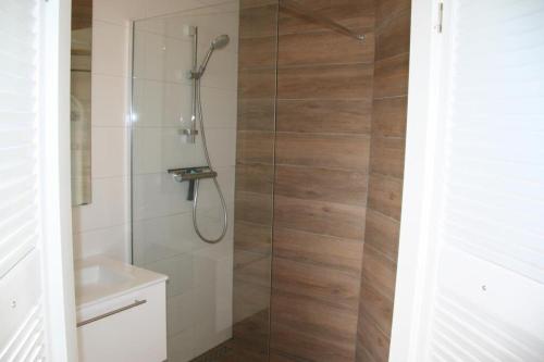 a bathroom with a shower with a glass door at Heggerank 54 in Nieuwvliet