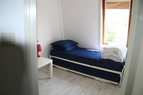 a small bedroom with a bed and a window at Heggerank 54 in Nieuwvliet