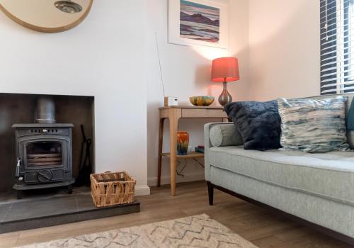 a living room with a couch and a wood stove at Sunset Retreat in Gullane