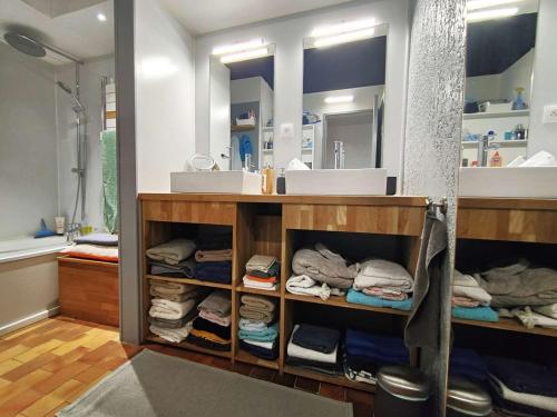 une salle de bain avec un lavabo et une étagère avec des serviettes dans l'établissement Villa lumineuse avec grand jardin, au calme, proche plages et commerces au cœur de Petit-Piquey - FR-1-736-30, à Lège-Cap-Ferret