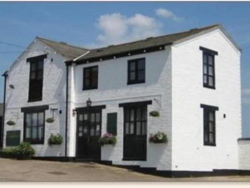 a white house with black windows and doors at The Shoulder of Mutton in Calverton