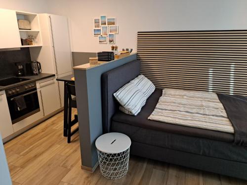 une petite chambre avec un canapé et une cuisine dans l'établissement Ferienwohnung Port Marina 419, das Hafen-Apartment in perfekter Lage!, à Bremerhaven