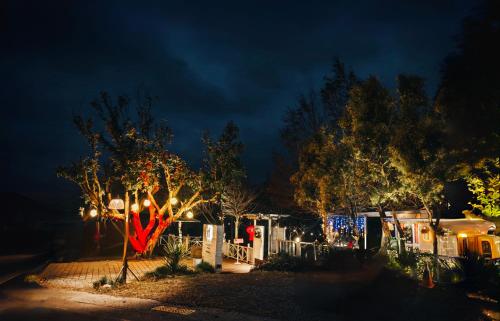 a yard with a fence and a tree with lights at 好和院景 How Has in Chishang