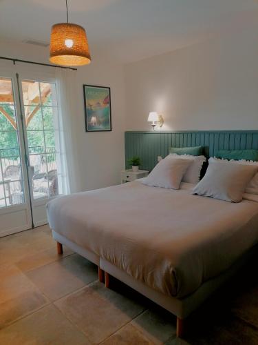 ein Schlafzimmer mit großem Bett und Balkon in der Unterkunft Entre 2 Mers - Charming guesthouse in Cancon