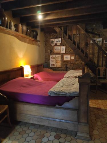 - une chambre avec un grand lit et un escalier dans l'établissement ferme de la gortiere, à Le Teilleul