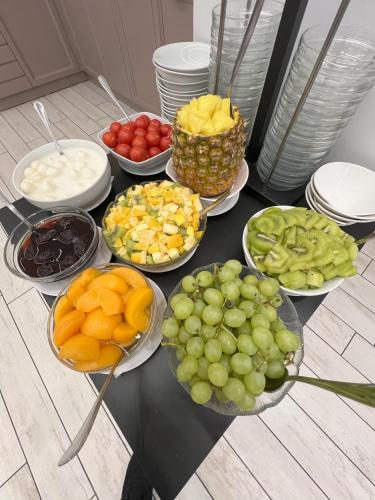 a table topped with bowls of fruit and plates of food at Hotel Giotto in Padova