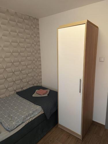 a small bedroom with a bed and a closet at Apartament Japko in Gliwice