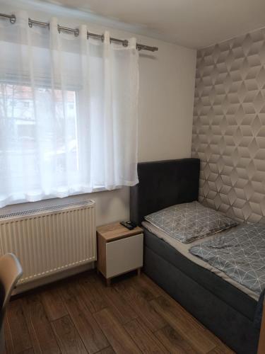 a small bedroom with a bed and a window at Apartament Japko in Gliwice