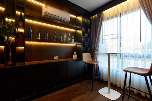a bar with two stools and a shelf with bottles at Modern Elegance Pool Villa in Chiang Mai