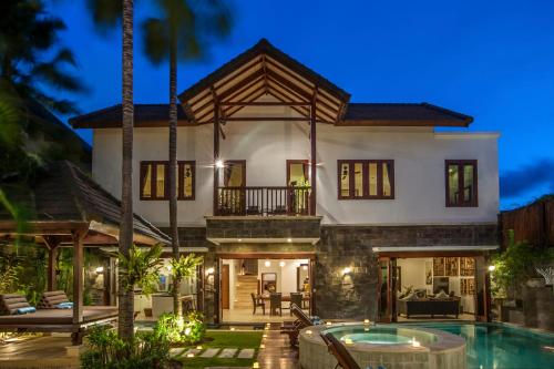 a villa with a swimming pool at night at Villa Annecy in Seminyak