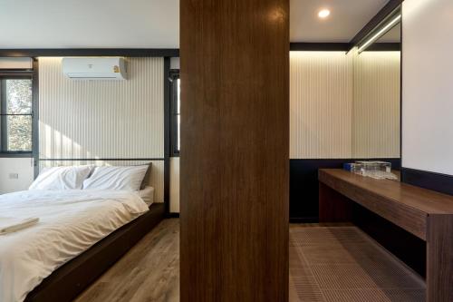 a bedroom with a bed and a wooden wall at Modern Elegance Pool Villa in Chiang Mai