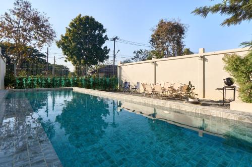 a swimming pool with blue water in a yard at Modern Elegance Pool Villa in Chiang Mai