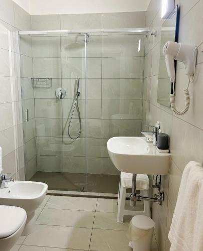 a bathroom with a shower and a sink and a toilet at Hotel Donatello in Modena