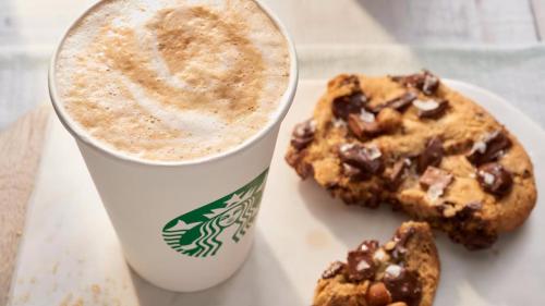 a cup of coffee and a cookie on a plate at Courtyard by Marriott Gulfport Beachfront in Gulfport