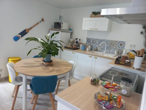 a kitchen with a table and a table and chairs at Les Pieds dans le sable in Le Crotoy