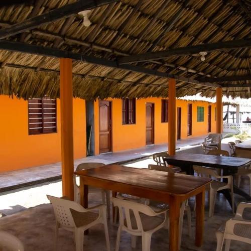 Un patio con mesas y sillas en un edificio. en Cabañas Capilla Del Mar, en San Bernardo del Viento