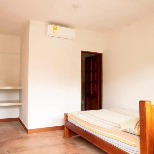 Un dormitorio con una cama en una habitación con una pared. en Cabañas Capilla Del Mar, en San Bernardo del Viento