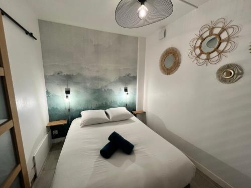 - une chambre dotée d'un lit blanc avec un objet noir dans l'établissement Le Globe Nantais, à Nantes