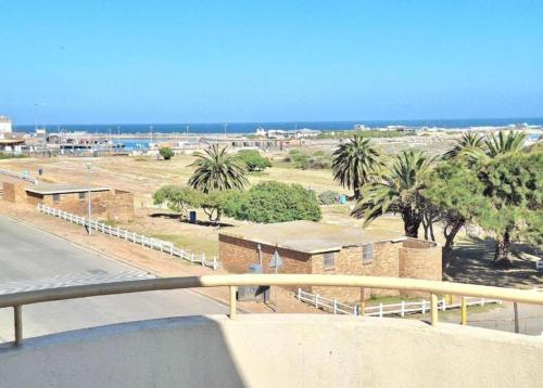a view of a beach with palm trees and buildings at Meeulekker op Lambertsbay in Lambertʼs Bay