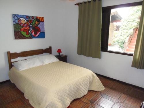 a bedroom with a bed and a window at Pousada da Villa in Imbituba