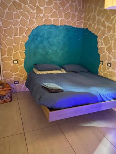 a bed in a room with a stone wall at Fantasy House in Cremona