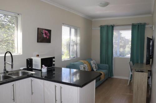 a kitchen with a sink and a living room at Tygerviews on Uys in Tygerberg Hills