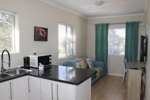 a kitchen with a sink and a living room at Tygerviews on Uys in Tygerberg Hills
