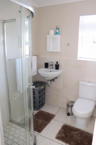 a bathroom with a toilet and a sink and a shower at Tygerviews on Uys in Tygerberg Hills