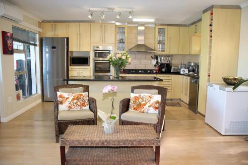 a kitchen with two chairs and a table with flowers on it at Tygerviews on Uys in Tygerberg Hills