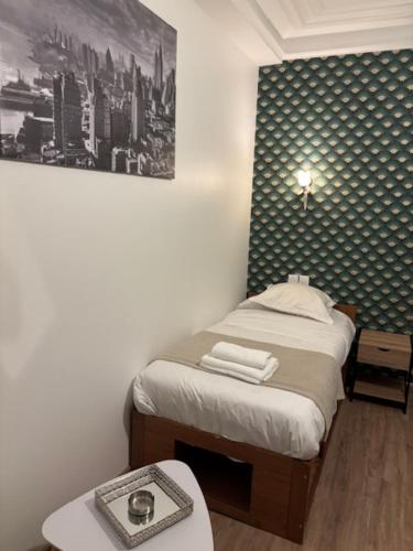 - une petite chambre avec un lit et une table avec un plateau dans l'établissement STUDIO TOUT EQUIPE 50 M DE LA GARE D'ENGHIEN LES BAINs 15 MN DE PARIS CENTRE, à Enghien-les-Bains