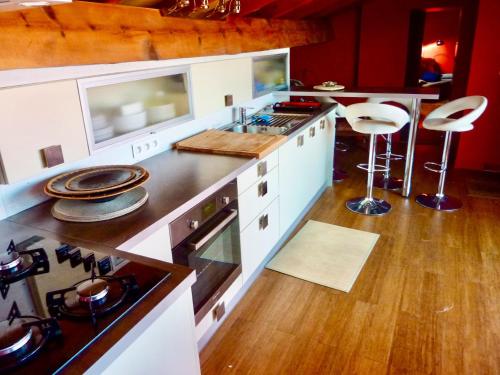 une cuisine avec une cuisinière et un comptoir dans l'établissement Beau loft en centre-ville vue mer, à LʼÎle-Rousse