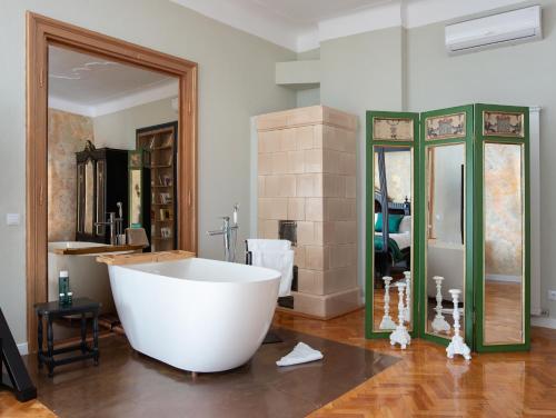 a large bath tub in a bathroom with a large mirror at MAGISTER seven in Sibiu