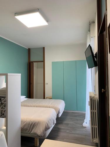 ein Zimmer mit zwei Betten und einem Flachbildfernseher in der Unterkunft Nice Room in Busto Arsizio