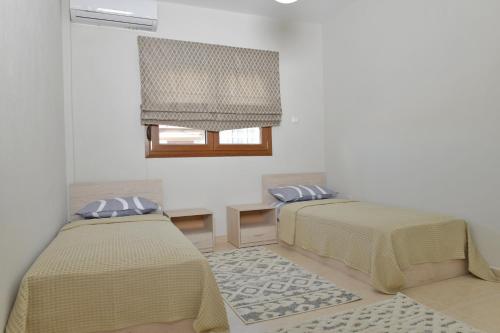 a room with two beds and a window at Poli's Luxury suite @ N. Moudania in Nea Moudania