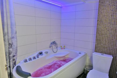a white bathroom with a tub and a toilet at Poli's Luxury suite @ N. Moudania in Nea Moudania